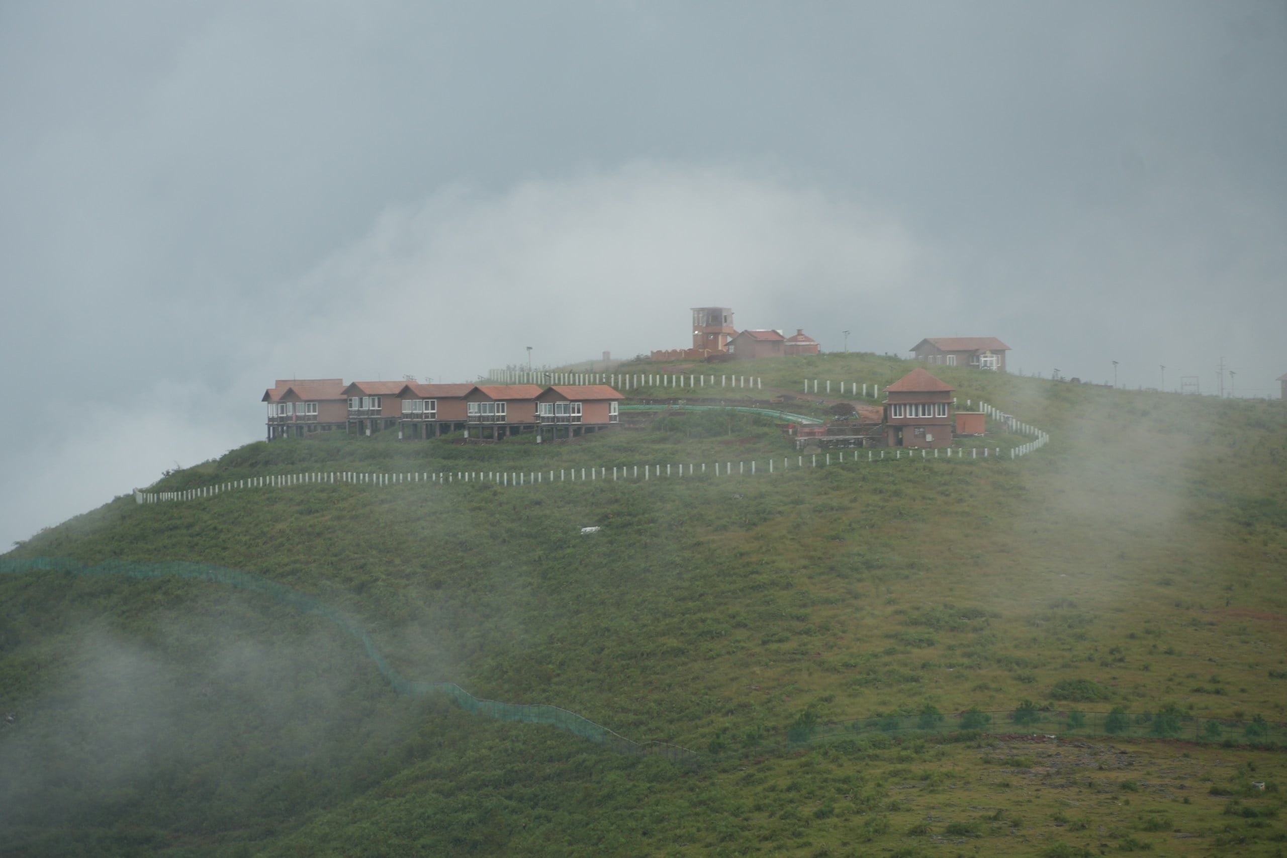 Buildings on a misty green hillside